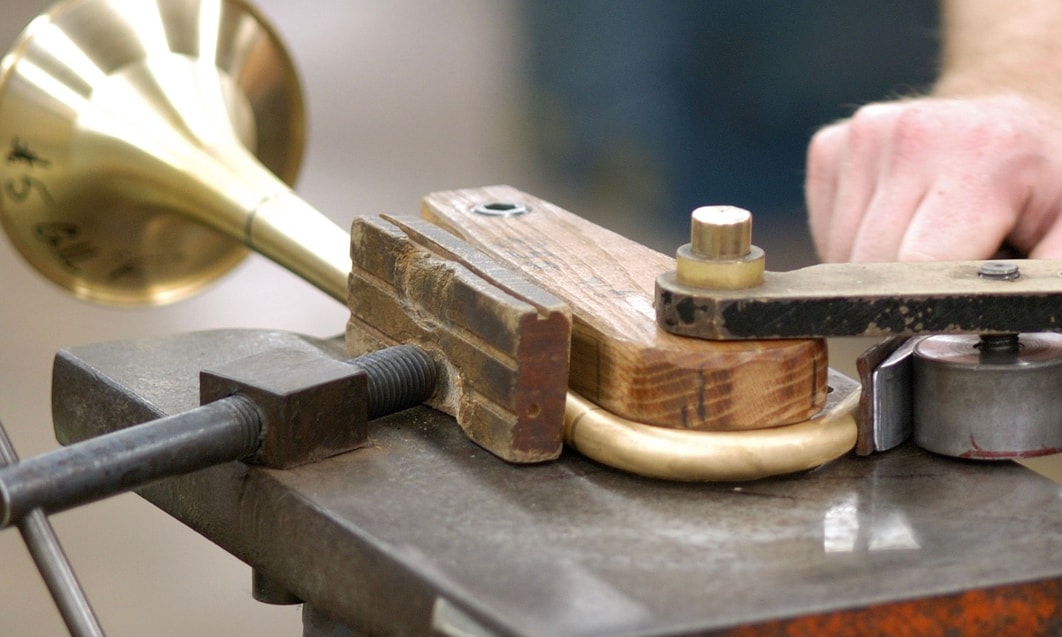 a hand holding a brass horn