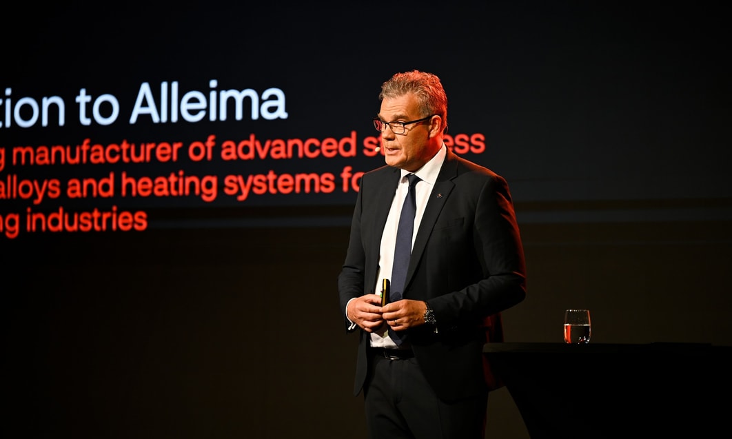 en person i kostym som står framför en skärm