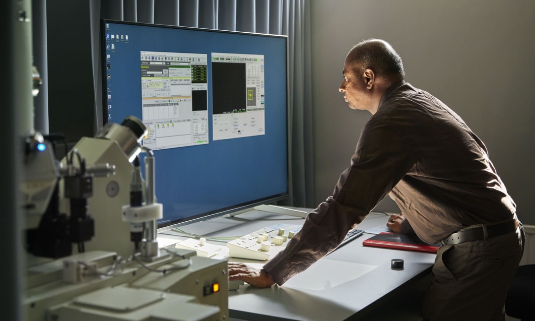 a person sitting at a desk looking at a computer screen