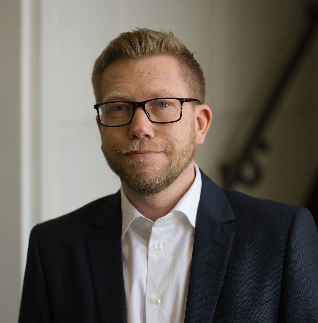 a person in a suit and glasses