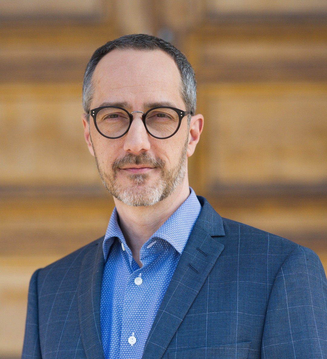 a person wearing glasses and a suit