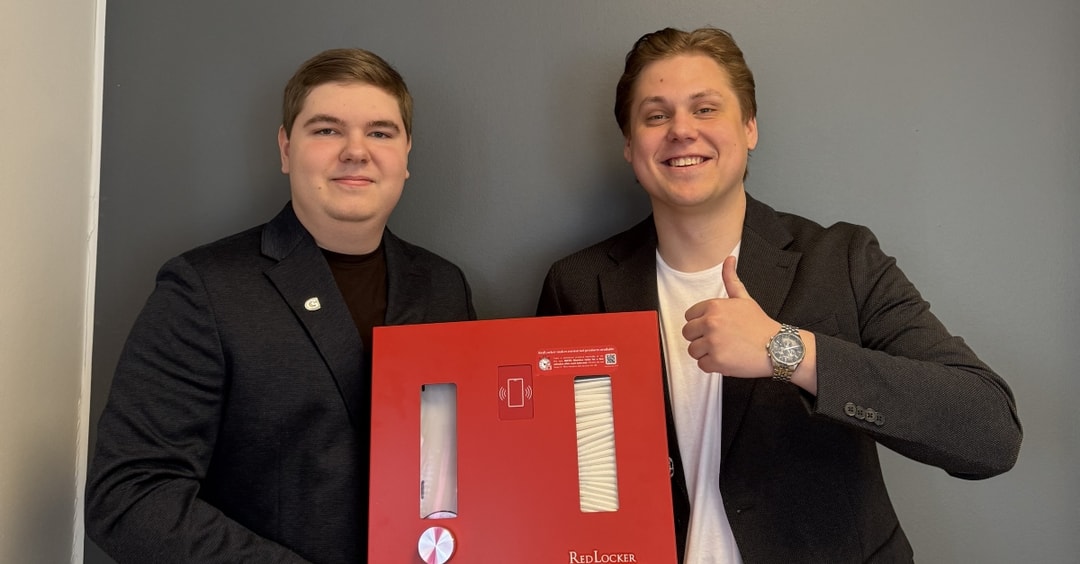 två män som håller i en röd låda