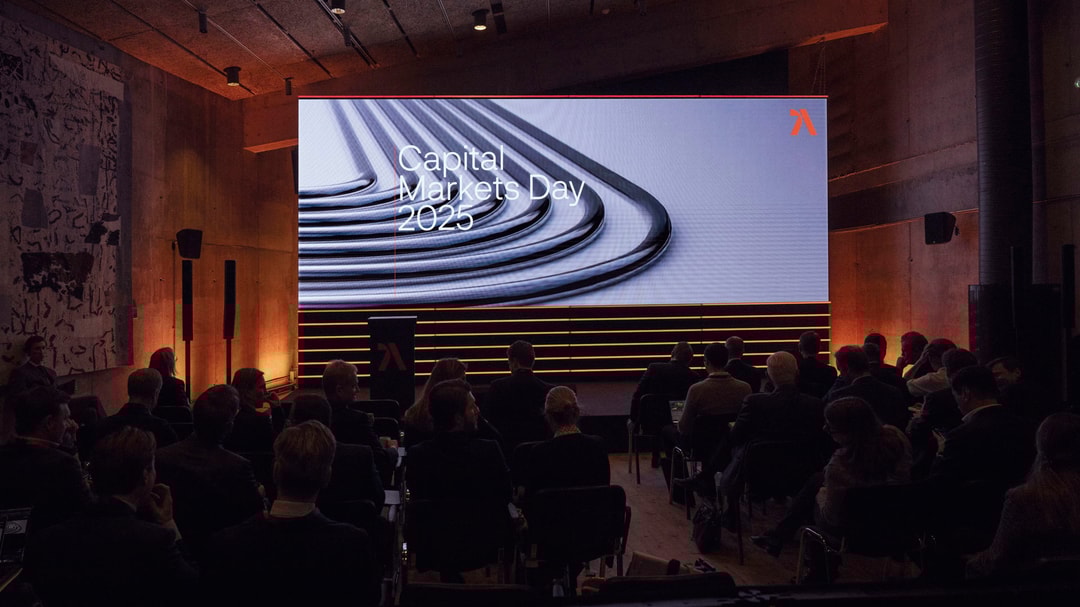 a group of people sitting in chairs in front of a large screen