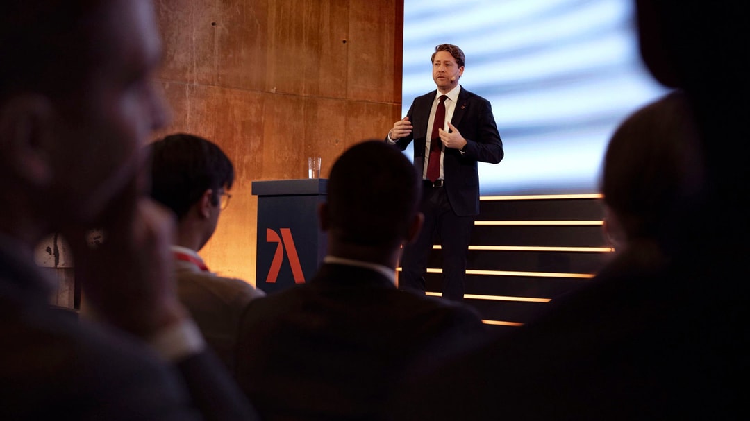 a person standing on a stage giving a presentation