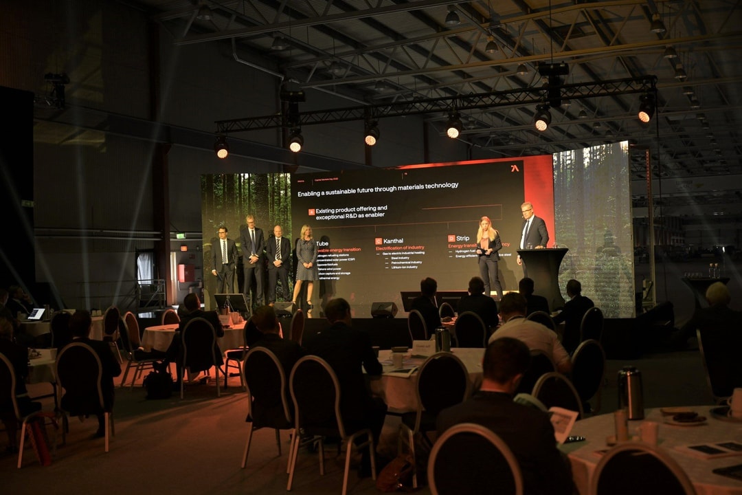a group of people standing in front of a large screen