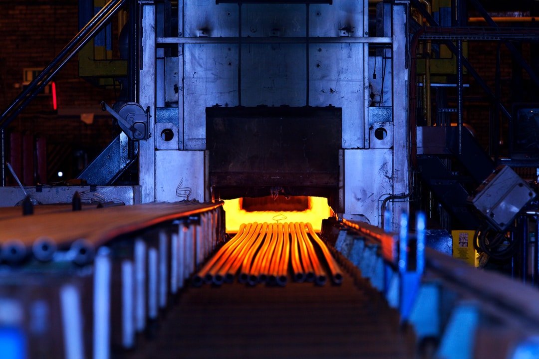 a machine with a conveyor belt and a large metal tube