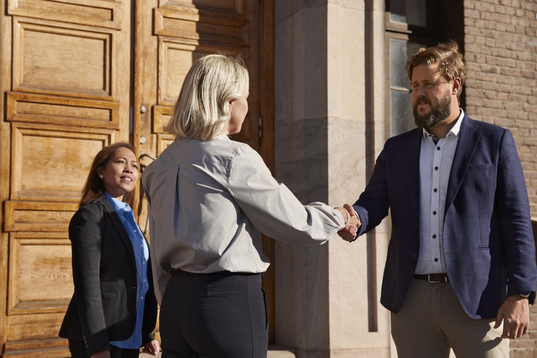 a person and person shaking hands outside a building