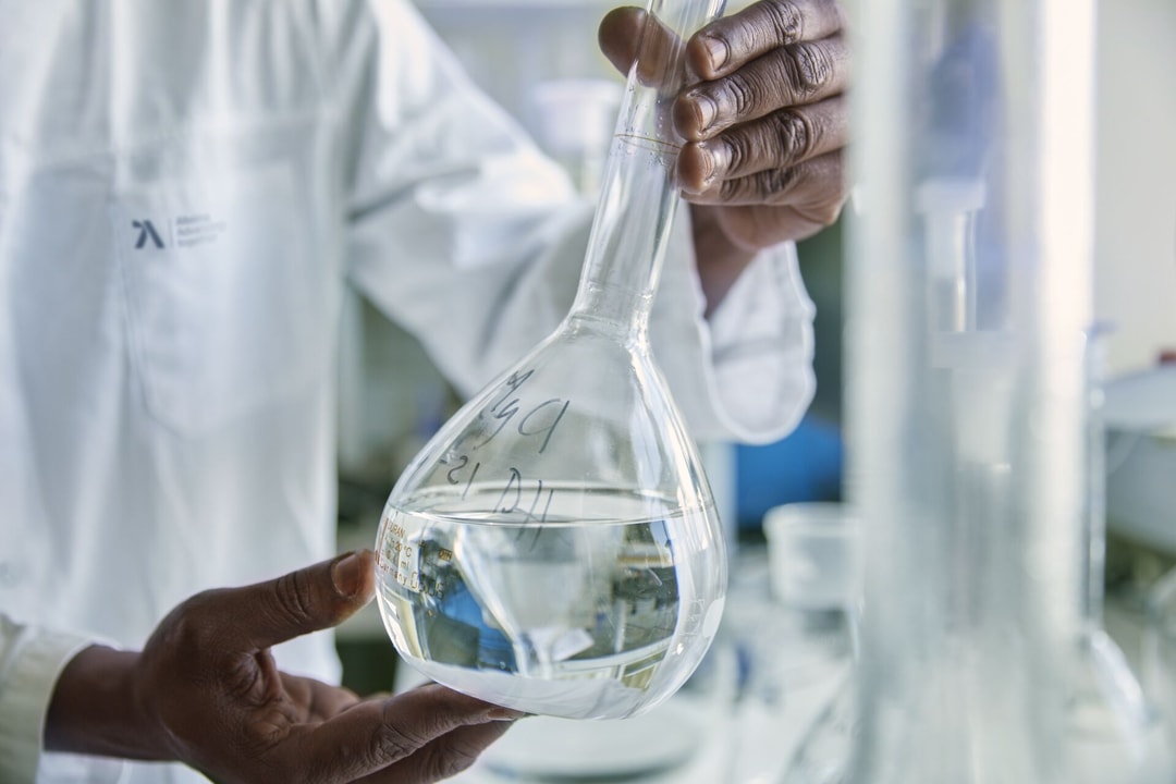 a person holding a beaker with liquid in it