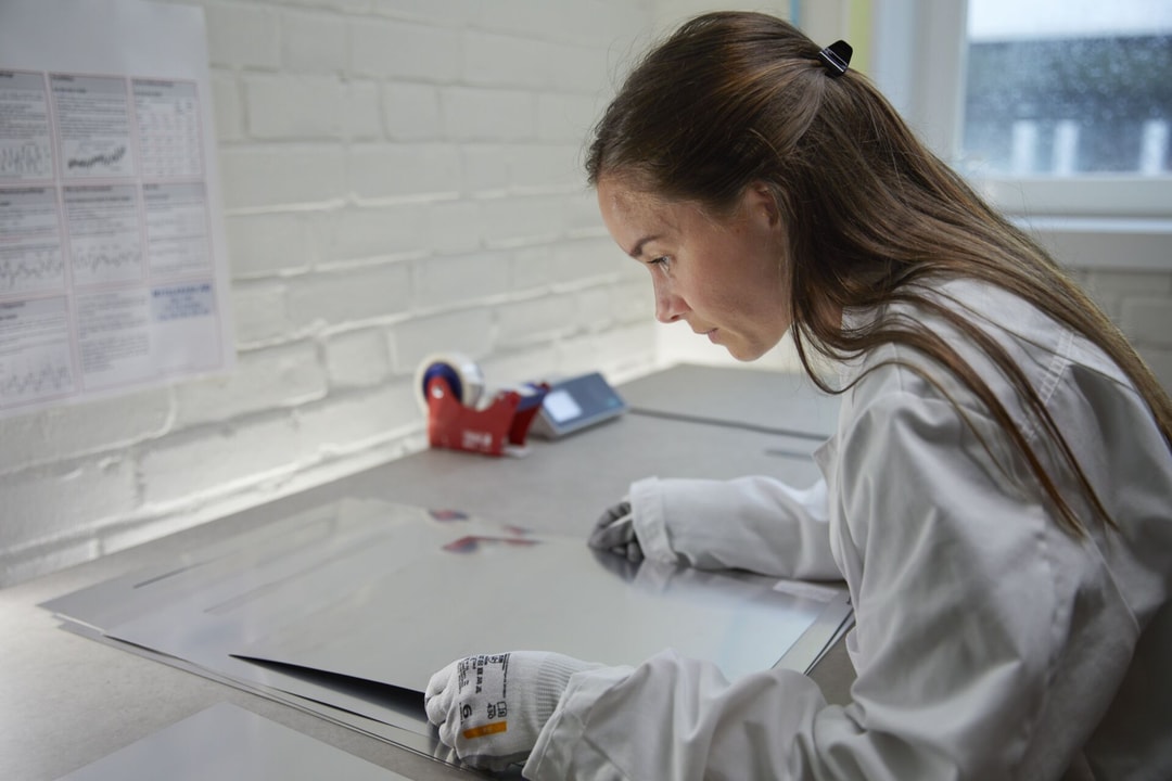 a person in a white coat looking at a piece of paper