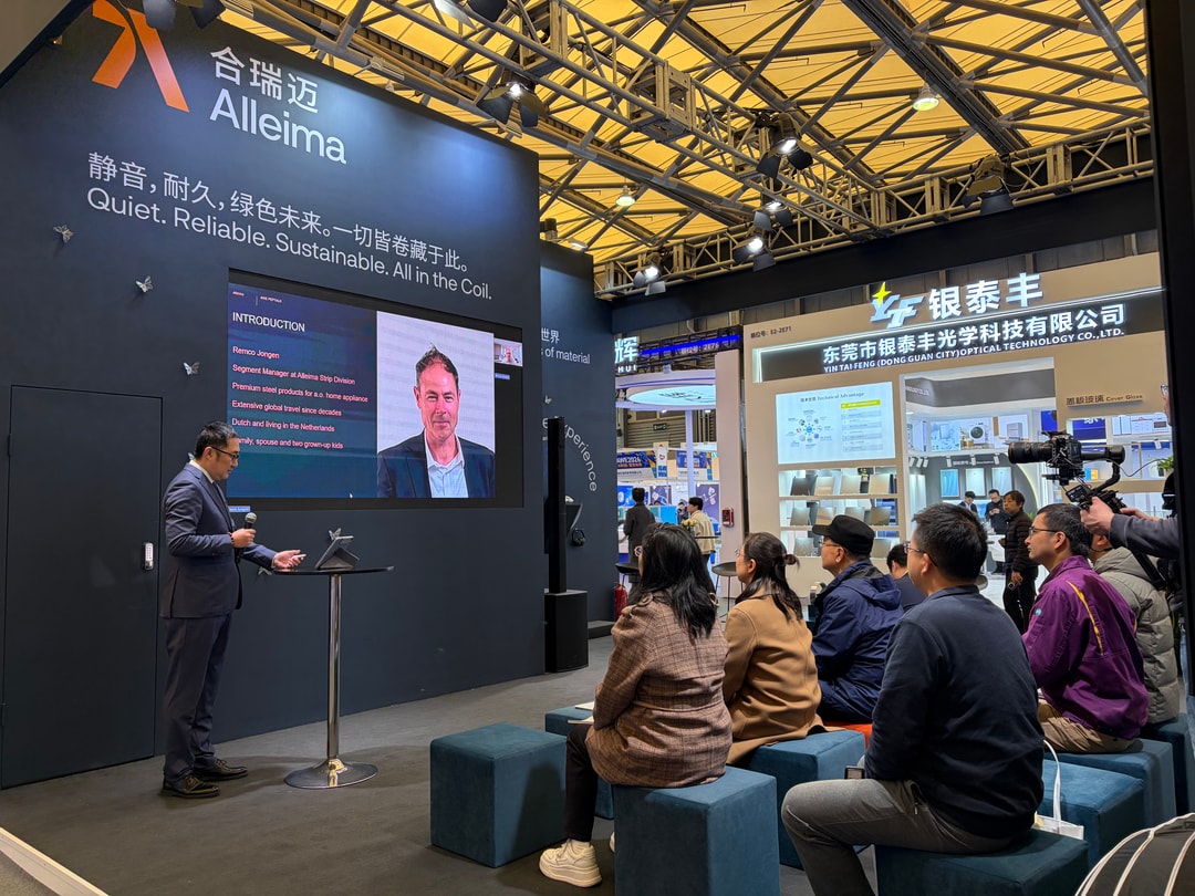 a person standing at a podium with a screen on the wall