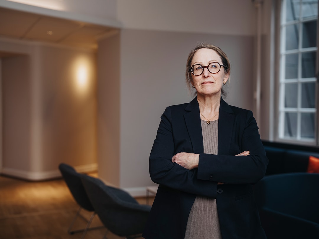 a person in a suit with her arms crossed