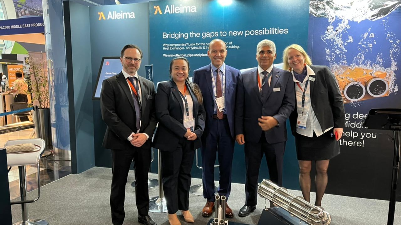 a group of people standing in front of a blue wall