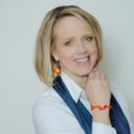 a person smiling with a hand on her chin