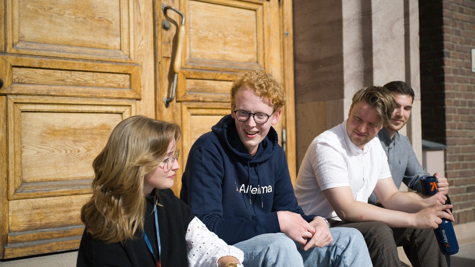 en grupp människor som sitter på en stenbänk