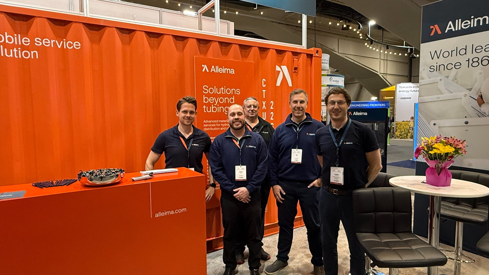 a group of men standing in front of an orange container