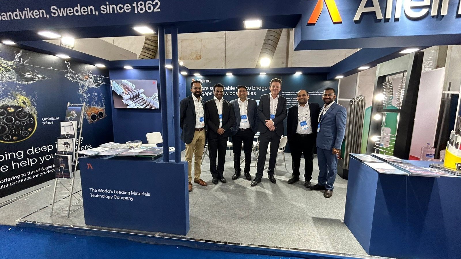 a group of men standing in front of a blue booth