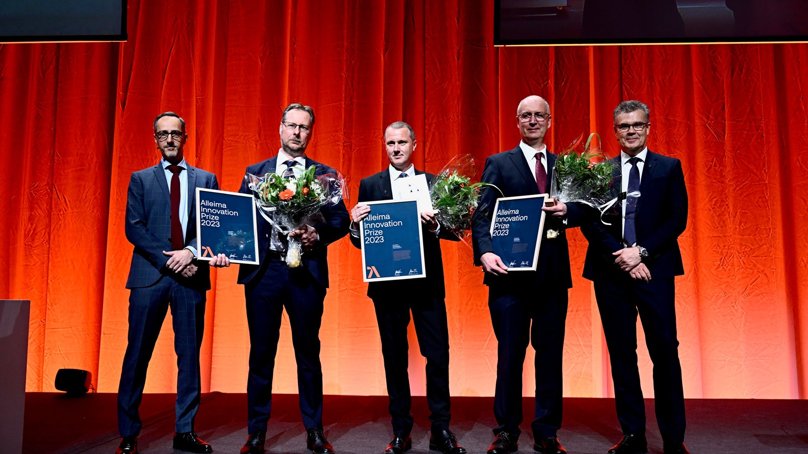 a group of men holding flowers and a sign