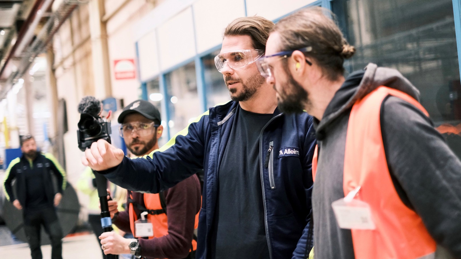 a group of men wearing safety goggles and standing in a building