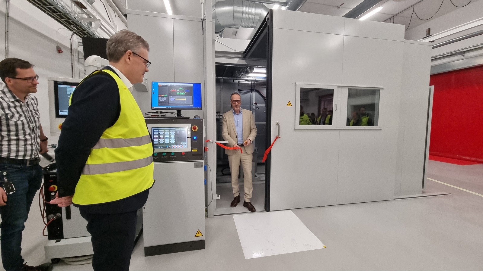 a person standing in a room with a person in a yellow vest