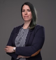 eine Person mit grünen Haaren, die einen Anzug und ein gestreiftes Hemd trägt