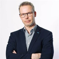 a person in a suit with his arms crossed