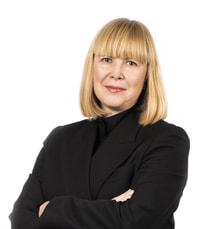 a person with blonde hair wearing a black suit