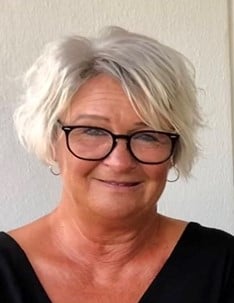 a person with glasses smiling