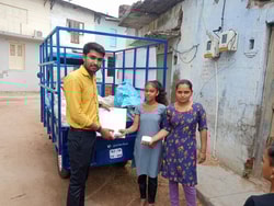 a group of people standing next to a blue truck