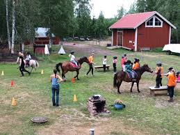 en grupp människor som rider på hästar på en äng