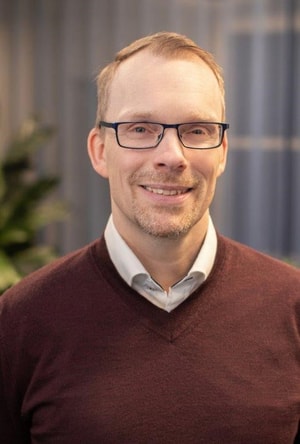 a person wearing glasses and a sweater