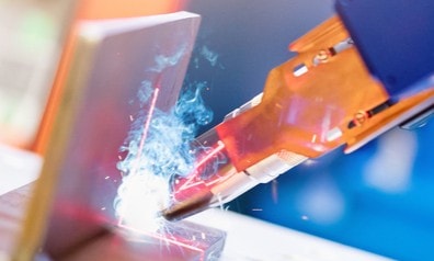 a close-up of a robot welding a piece of metal