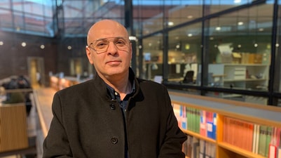 a person wearing glasses and a black coat