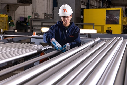 a person wearing a hard hat and gloves working in a factory