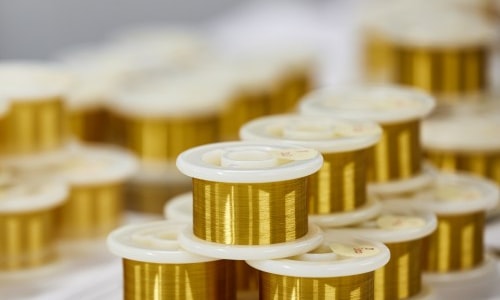 a group of gold wire spools