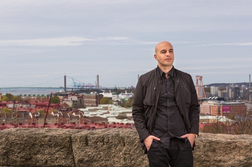 a person standing on a ledge with a city in the background
