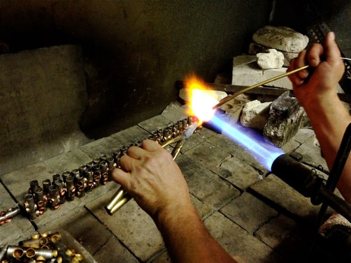 a person holding a torch and burning a piece of metal