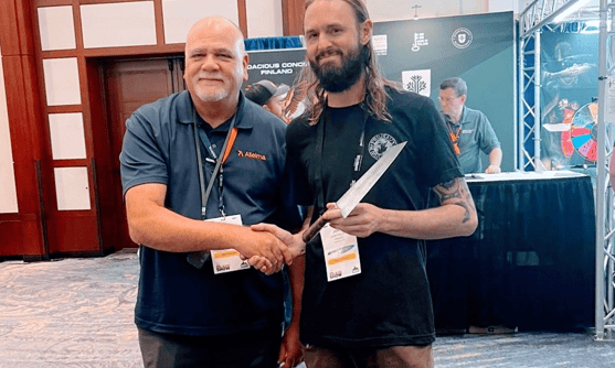 two men shaking hands with a knife