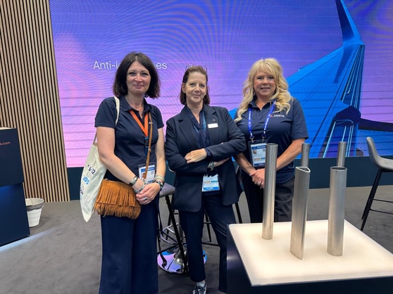 a group of women standing in front of a large screen