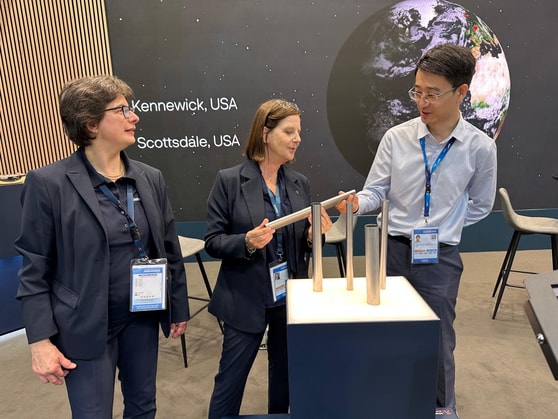 a group of people standing next to a metal object