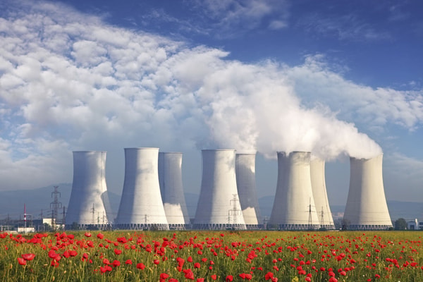 a group of nuclear power plant with smoke coming out of the chimney