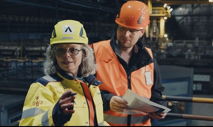 a person and person wearing hard hats and orange vests